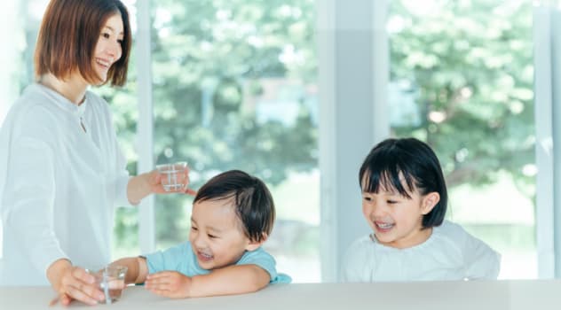笑顔で水を飲む家族の写真